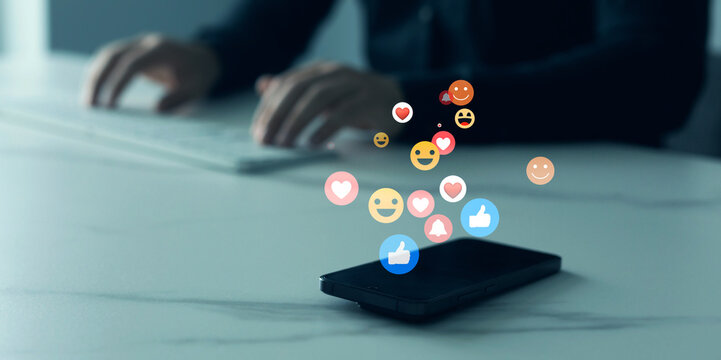 Person using smart phone with emoticon icons of Social Media.Interactive with friends on chat with emoticon feedback.Social media,marketing, like,social network,blog,live,chat reaction and livestream.