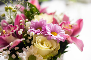 Beautiful bouquet with orchids, daisies, and roses. Natural freshness and elegance in daily workspace environment.
