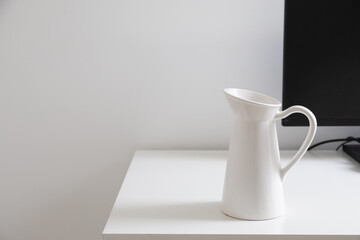 White jug on minimal desk. Calm atmosphere, everyday object, and simplicity of modern home life. Copy space