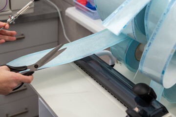 A medical professional uses a constant heat sealing machine to create sterilization pouches