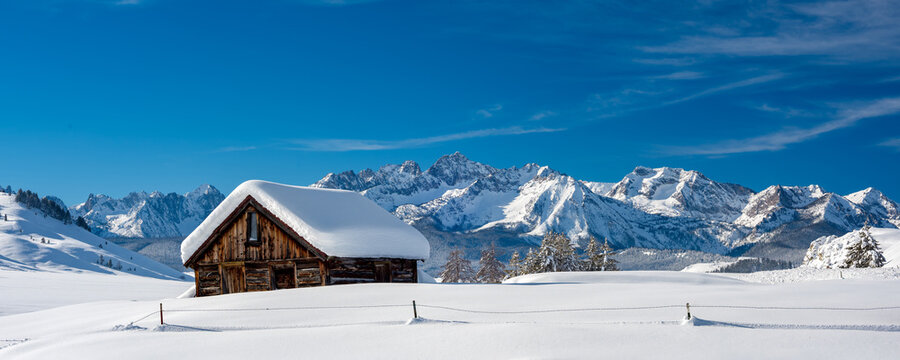 Winter cabin in the Sawtooths with snow and blue sky