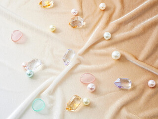 Pastel fabric background with pearls and crystals, soft luxury flat lay
