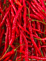 A vibrant and fiery display of fresh red chili peppers, piled abundantly and ready to add intense flavor and a spicy kick to any delicious culinary dish