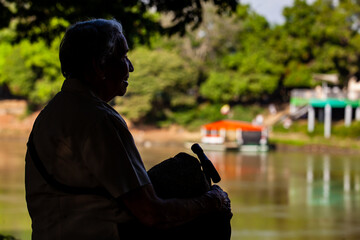 Senior woman at the Ronda del Sinu walking path along the river bank in the city of Monter&iacute;a, Colombia.