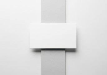 Blank white rectangular card placed vertically on two textured grey blocks against a white background