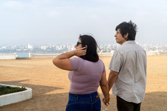 Young couple holding hands enjoying city view
