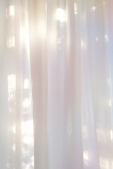 background of white transparent curtains illuminated by soft sunlight. Hazy glow and subtle shadows.