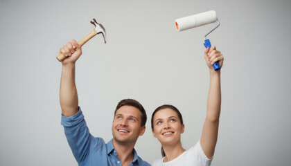 Couple with renovation tools against white wall