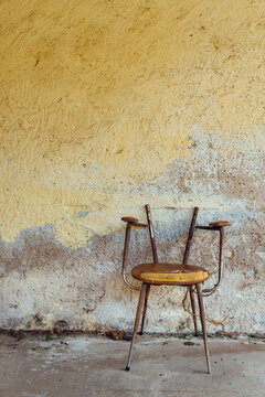 une vieille chaise cass&eacute;e et abandonn&eacute;e dans un squat. Chaise de guetter dans la banlieue. D&eacute;chet dans la ville. Mur d&eacute;cr&eacute;pi dans une ancienne maison d&eacute;sert&eacute;e