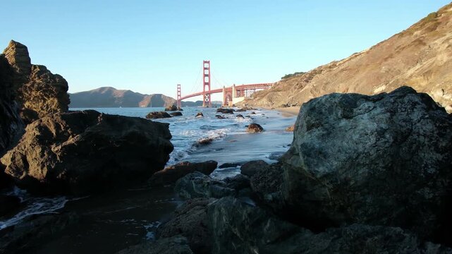 The Golden Gate Bridge viewed from the western side during dusk from Marshalls Beach with the beach and coast in the foreground.