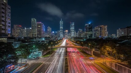 Illuminated city skyline with busy highway traffic trails at night - Powered by Adobe