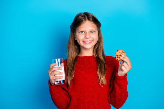 Happy girl in a red sweater holds milk cookie blue background perfect for christmas holiday shopping family lifestyle stock photography - Powered by Adobe