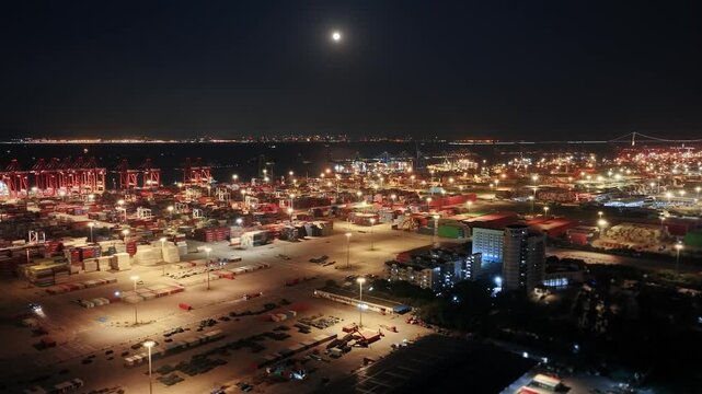 Unloading large cargo containers seaport. Loading freight sea port. Top aerial drone view. Lot big boxes rows, ship delivery ocean harbor. Shipping night. Goods export import. Industrial Marine dock.