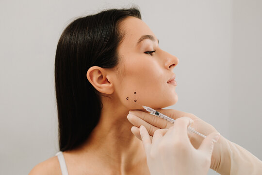Bruxism injecting for teeth grinding by a cosmetologist. Bruxism injection facial for a treatment with botulinum toxin in an aesthetic medicine clinic.