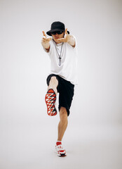 Young hip-hop dancer in street style summer outfit isolated on light background