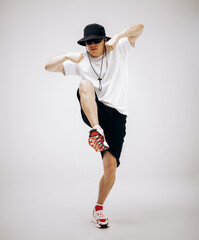 Young hip-hop dancer in street style summer outfit isolated on light background
