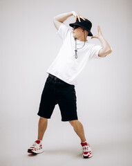 Young hip-hop dancer in street style summer outfit isolated on light background