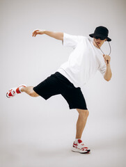 Young hip-hop dancer in street style summer outfit isolated on light background