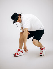 Young hip-hop dancer in street style summer outfit isolated on light background