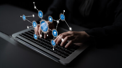 A close-up view of hands typing on a laptop in a dark office, surrounded by digital icons symbolizing global connectivity and innovative technology interaction. Tessel