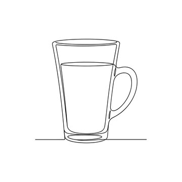 Clear latte glass filled with beverage on a simple surface  