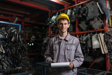 Male technician worker working in secondhand automotive car spare parts warehouse. Used auto parts industry