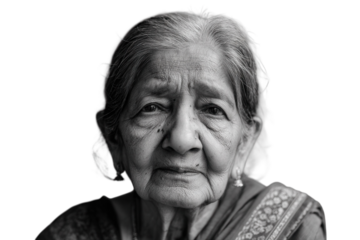 Elderly Indian woman with white hair looking hopeful on light grey background.