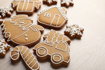 Tasty gingerbread cookies on light wooden table, closeup