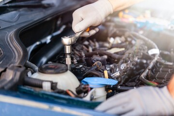 Car mechanic working with motor of a car.