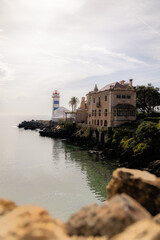 Elegant villa and iconic Santa Marta Lighthouse on the peaceful waterfront of Cascais, Portugal at midday