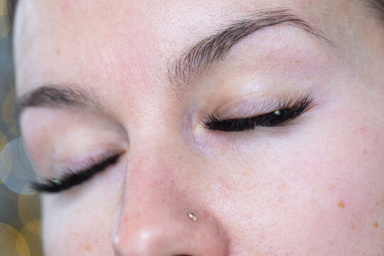 A woman has long extended eyelashes in a close-up with rhinestones. Preparing the image for the holiday
