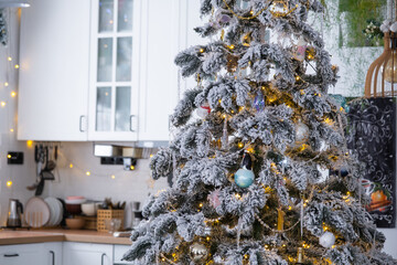 Christmas decor in white kitchen, mess dishes, contemporary interior with a snowy Christmas tree...