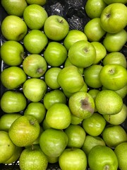 Green apples stacked in abundance, showcasing fresh produce and healthy eating concepts