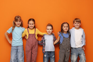 Obraz premium Cute little kids posing on orange background