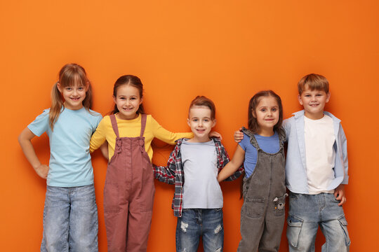 Cute little kids posing on orange background