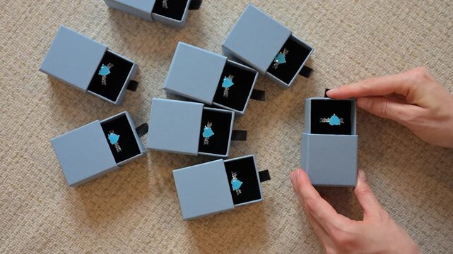 Jeweler carefully placing handmade turquoise rings into small gift boxes, preparing for shipment or display