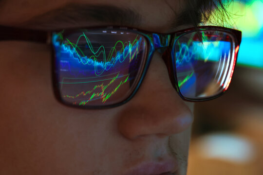 Man wearing glasses with reflection on blurred background, closeup