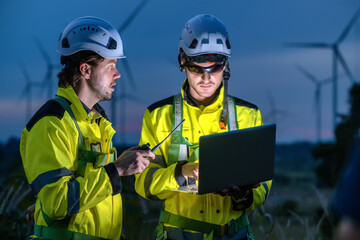 Engineers Team Night Communication Laptop Monitoring Wind Turbine. Night Time Renewable Energy...
