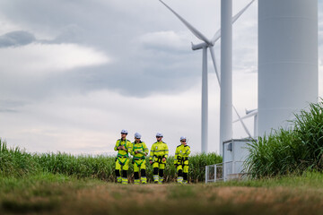 Four Technicians Safety Harness Walking Wind Turbine Inspection. Mission Operation Renewable Power Site. Future Grid Maintenance Crew Specialized Safety Equipment. Wide angle with Copy Space