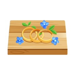 Close-up view of golden wedding rings and beautiful small blue flowers on wooden tabletop