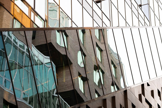 Wide angle reflection of modern glass facade capturing geometry and design of urban architecture building windows under clear blue daylight atmosphere