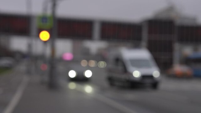 Out-of-focus ambulance with flashing lights in city traffic