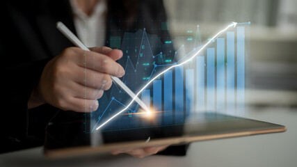 A business professional uses a digital tablet to analyze data trends, showcasing futuristic graphs and emphasizing finance strategies for growth and productivity. Impute