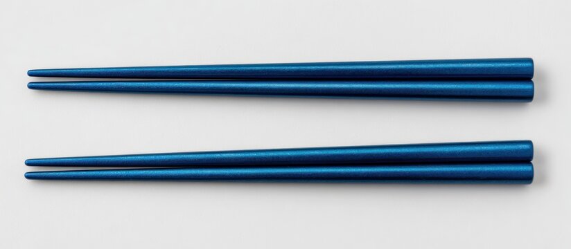 Pair of blue chopsticks on a white background, parallel and slightly tapered - Powered by Adobe
