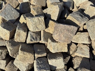 Pile of square cobblestones in various natural tones, used for paving