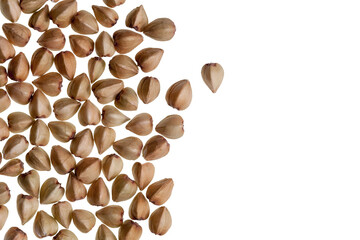 Obraz premium Buckwheat seeds scattered on a white background. Triangular grains used in gluten-free diets, vegan cooking, and sustainable agriculture.