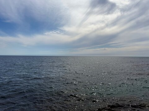 Beautiful sea dark blue glittering waves and cloudy sky.