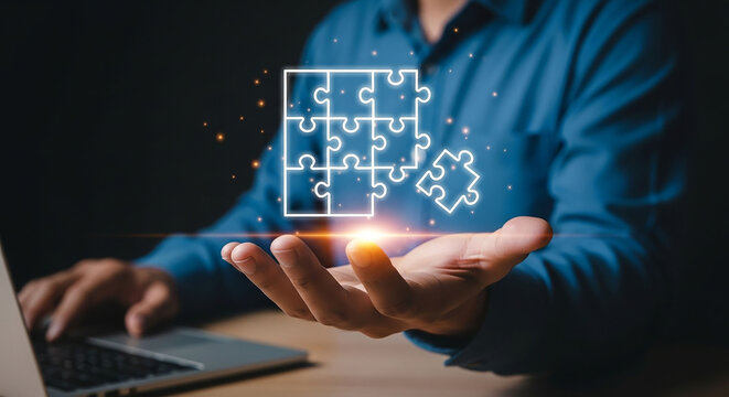 Businessman holding a glowing digital puzzle piece, symbolizing finding a business solution and strategy.
