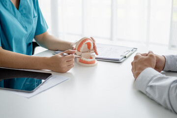 dentist assesses teeth during a patient consultation in a clinic room
