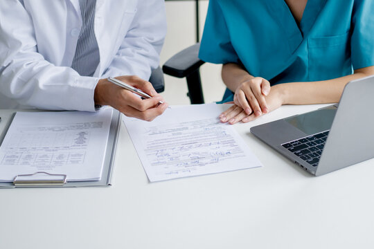 Doctor and nurse consulting on patient medical record in hospital
